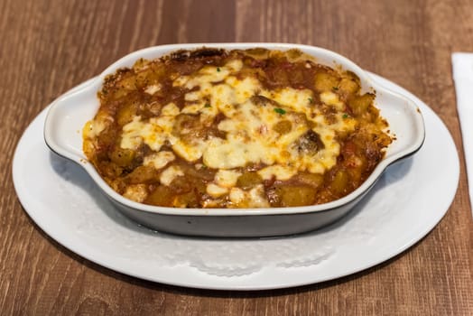 Spicy beef with cheese potatoes and rice dish on a wooden table