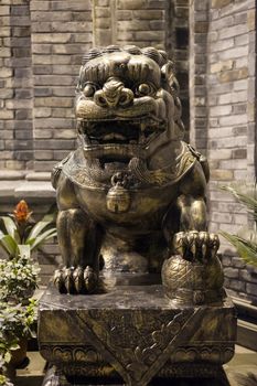 Lion bronze statue at night in a chinese street in Chengdu, China