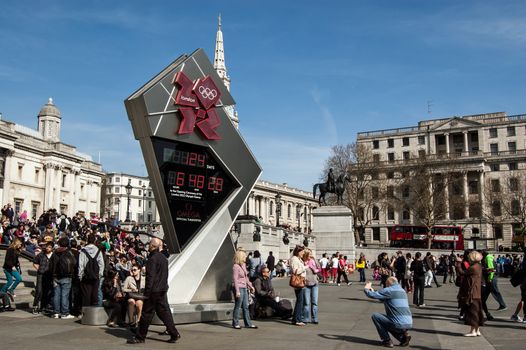 London, UK - March 25, 2012:  Tourists gathering around the clock counting down the time until the start of the Olympic Games in the city.  