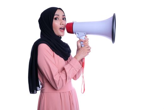 Young muslim woman in hijab clothes holds in hand bullhorn public address megaphone isolated on yellow background studio portrait. People religious lifestyle concept. Mock up copy space