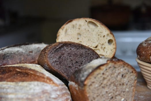 A fresh crusty loaf of homemade bread. Homemade rustic sour. Brown bread. Different types of loaves. Sliced Bread. Atmosphere image of a countryside style kitchen.