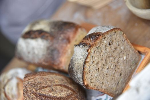 A fresh crusty loaf of homemade bread. Homemade rustic sour. Brown bread. Different types of loaves. Sliced Bread. Atmosphere image of a countryside style kitchen.