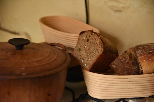 A fresh crusty loaf of homemade bread. Homemade rustic sour. Brown bread. Different types of loaves. Sliced Bread. Atmosphere image of a countryside style kitchen.