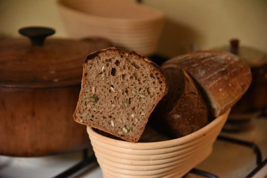 A fresh crusty loaf of homemade bread. Homemade rustic sour. Brown bread. Different types of loaves. Sliced Bread. Atmosphere image of a countryside style kitchen.