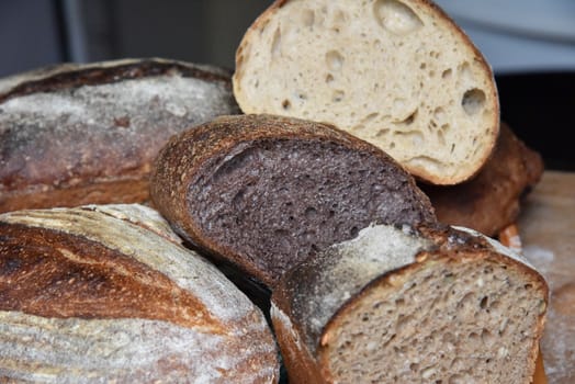 A fresh crusty loaf of homemade bread. Homemade rustic sour. Brown bread. Different types of loaves. Sliced Bread. Atmosphere image of a countryside style kitchen.