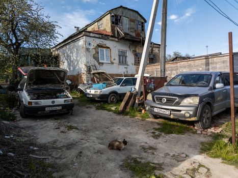 TULA, RUSSIA - MAY 23, 2020: Russian private building with car junkyard at summer daytime.