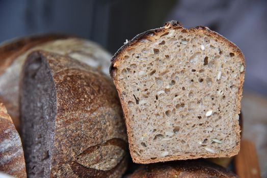 A fresh crusty loaf of homemade bread. Homemade rustic sour. Brown bread. Different types of loaves. Sliced Bread. Atmosphere image of a countryside style kitchen.