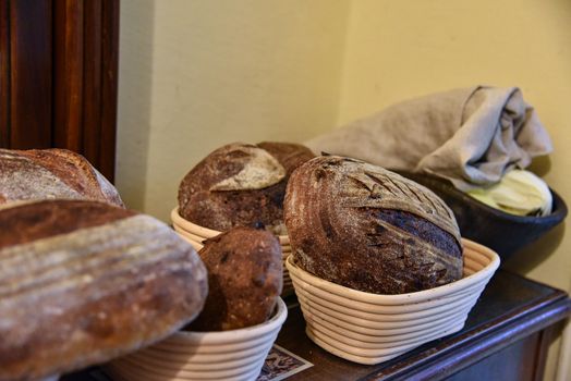 A fresh crusty loaf of homemade bread. Homemade rustic sour. Brown bread. Different types of loaves. Sliced Bread. Atmosphere image of a countryside style kitchen.