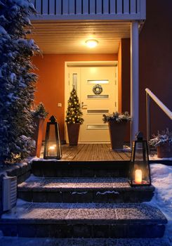 Welcome Christmas - house entrance snowy steps and door with decoration