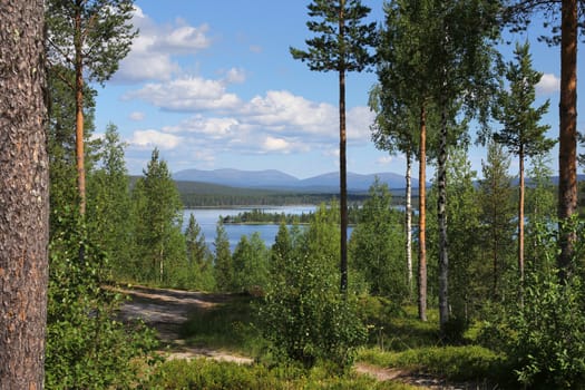 Beautiful Finnish Lapland summer lake scenery and hiking trail, with Pallastunturi fells on the horizon
