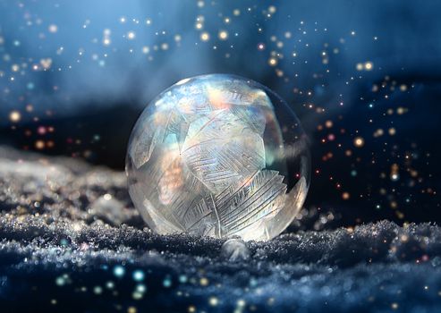 Magical color glitter frostball on cold winter snow, crystal formations, dark background