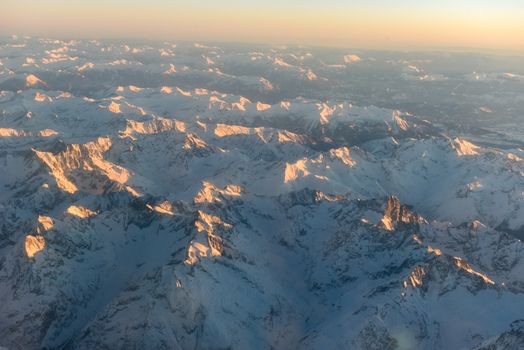 Aerial winter sunset view of the Alps