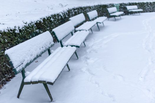 Benches under the snow in Trocadero gardens in winter in Paris, France