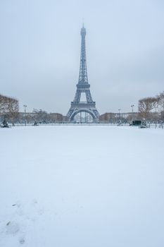 Eiffel tower under the snow in winter from the Champs de Mars in Paris, France