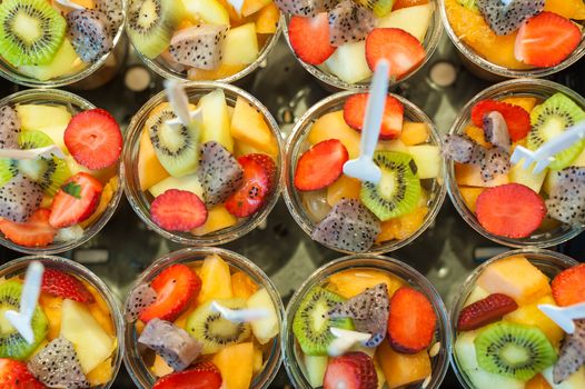 Cups of fresh fruit salad close-up in a market