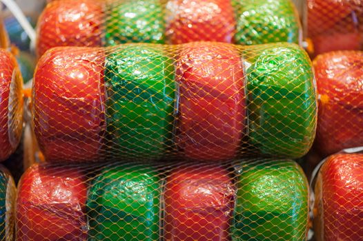 Net of green and red wheels of gouda cheese in a market in the Netherlands