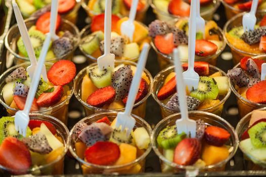 Cups of fresh fruit salad close-up in a market