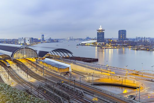 View of the Amsterdam train station and the Amstel river at night, Netherlands