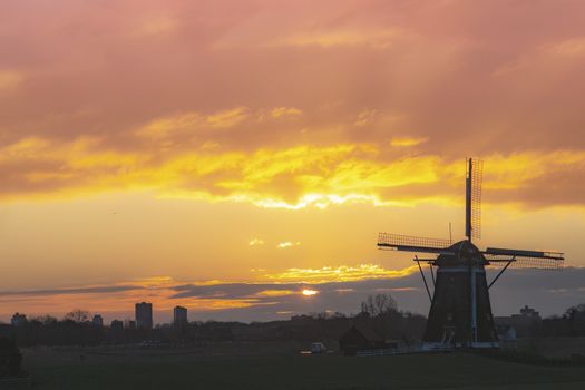 Warm and vibrant sunrise over the Unesco world heritage windmill in Leidschendam, Kinderdijk, Netherlands 