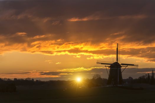 Warm and vibrant sunrise over the Unesco world heritage windmill in Leidschendam, Kinderdijk, Netherlands 