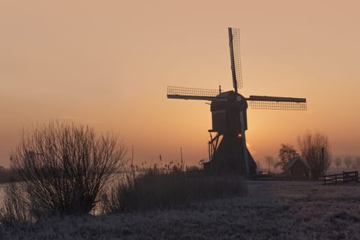 Windmill silhouette at the early morning sunrise in Netherlands