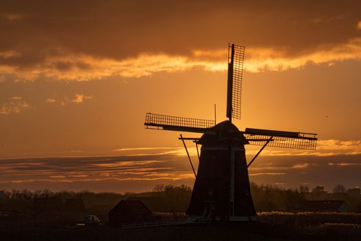 Warm and vibrant sunrise over the Unesco world heritage windmill in Leidschendam, Kinderdijk, Netherlands 