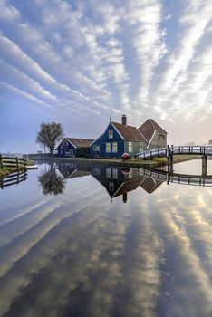 Beautiful and typical Dutch wooden houses architecture mirrored on the calm canal of Zaanse Schans located at the North of Amsterdam, Netherlands