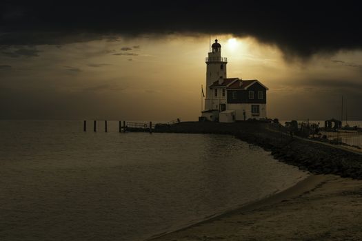 View of the white Marken island lighthouse under a foggy and cold skyline in the early morning, Netherlands