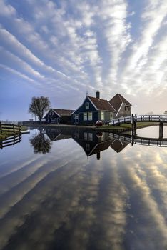 Beautiful and typical Dutch wooden houses architecture mirrored on the calm canal of Zaanse Schans located at the North of Amsterdam, Netherlands