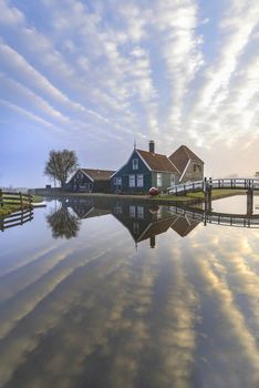 Beautiful and typical Dutch wooden houses architecture mirrored on the calm canal of Zaanse Schans located at the North of Amsterdam, Netherlands