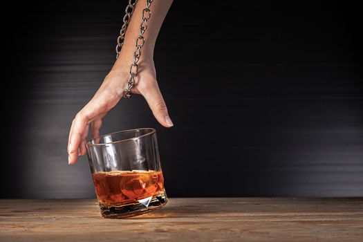 Alcoholism concept . Hands lock chain a glass of whiskey To stop drinking . Stop alcohol addiction . Addicting to alcoholic drink. 