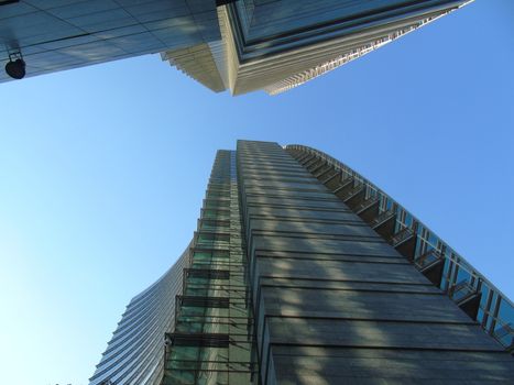 Milano, Italy - 02/14/2020: Amazing photography to the Skyscrapers of Milano in winter days with some people, a great blue sky and some details of the exterior part of the structure