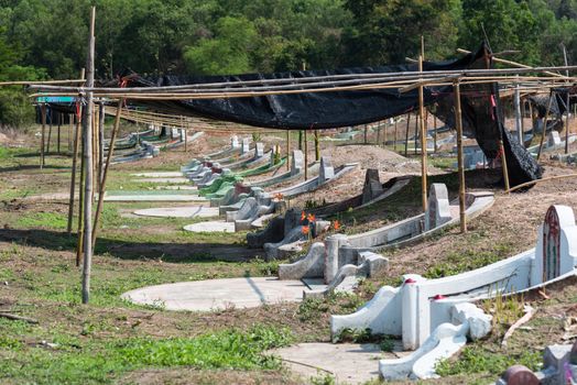 Prachinburi, Thailand - April 7, 2019 : Thai Chinese respect ancestors parents those died by food and burn fake money to sacrifice them at cemetery in Qingming Festival (Qing Ming), Tomb-Sweeping Day