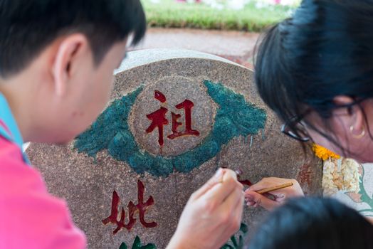 Prachinburi, Thailand - April 7, 2019 : Thai Chinese respect ancestors parents those died by food and burn fake money to sacrifice them at cemetery in Qingming Festival (Qing Ming), Tomb-Sweeping Day