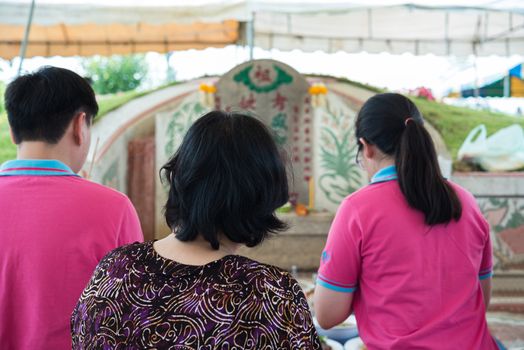 Prachinburi, Thailand - April 7, 2019 : Thai Chinese respect ancestors parents those died by food and burn fake money to sacrifice them at cemetery in Qingming Festival (Qing Ming), Tomb-Sweeping Day