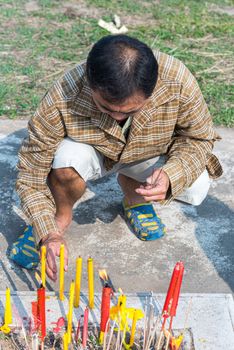 Prachinburi, Thailand - April 7, 2019 : Thai Chinese respect ancestors parents those died by food and burn fake money to sacrifice them at cemetery in Qingming Festival (Qing Ming), Tomb-Sweeping Day