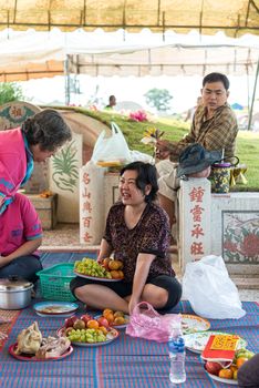 Prachinburi, Thailand - April 7, 2019 : Thai Chinese respect ancestors parents those died by food and burn fake money to sacrifice them at cemetery in Qingming Festival (Qing Ming), Tomb-Sweeping Day