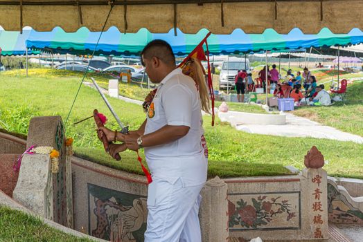 Prachinburi, Thailand - April 7, 2019 : Thai Chinese respect ancestors parents those died by food and burn fake money to sacrifice them at cemetery in Qingming Festival (Qing Ming), Tomb-Sweeping Day