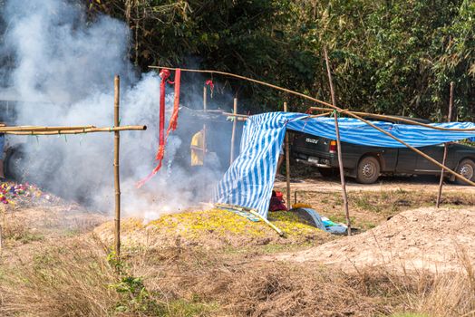 Prachinburi, Thailand - April 6, 2019 : Thai Chinese respect ancestors parents those died by food and burn fake money to sacrifice them at cemetery in Qingming Festival (Qing Ming), Tomb-Sweeping Day