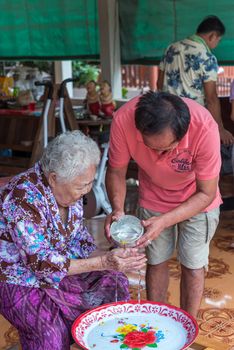 Ang Thong, Thailand - April 7, 2019 : Unidentified Asian people bathe respectation to elderly parents by water with jasmine, rose flower and aromatherapy in bowl in Songkran Festival (Thai New Year)