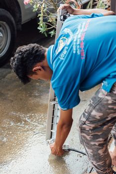 Bangkok, Thailand - January 12, 2020 : Unidentified worker to cleaning coil cooler of air conditioner by water for clean a dust on the wall in customer home when maintenance service