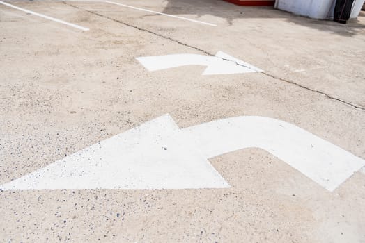 Arrow sign of turn, Old white painting on dirty concrete background.