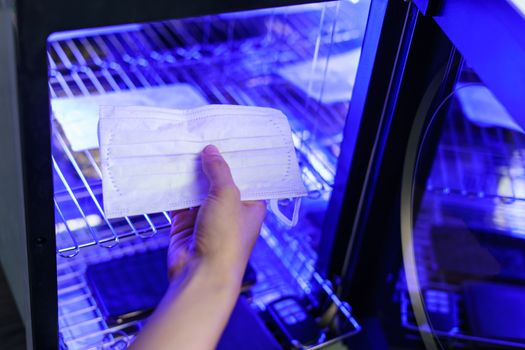 UV light sterilization of face mask to disinfection. COVID-19 prevention concept. ultra-violet sterilization and disinfection.