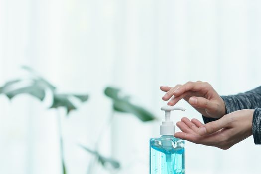 Woman cleaning her hands with sanitizer liquid antibacterial gel, in quarantine, corona virus concept.