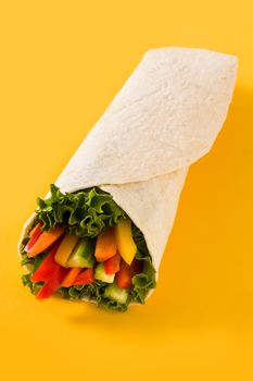 Vegetable tortilla wraps on yellow background