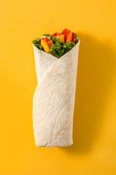 Vegetable tortilla wraps on yellow background
