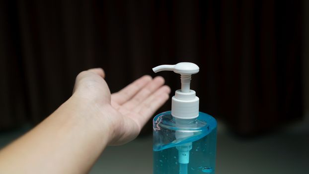 Man cleaning his hands with sanitizer liquid antibacterial gel, in quarantine, corona virus concept.