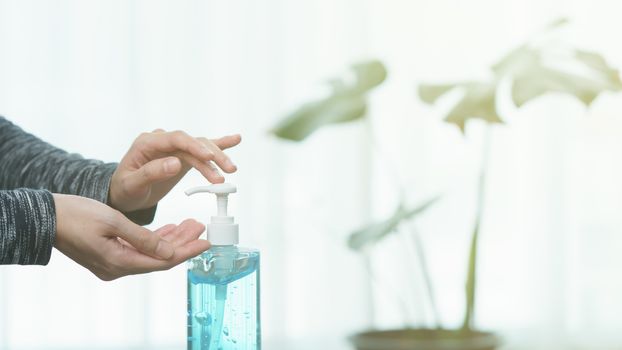 Woman cleaning her hands with sanitizer liquid antibacterial gel, in quarantine, corona virus concept.