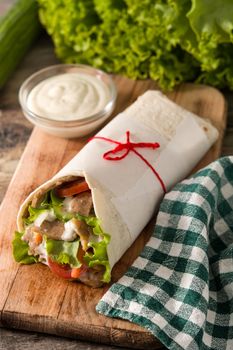 Doner kebab or shawarma sandwich on wooden table