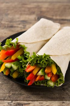 Vegetable tortilla wraps on wooden table